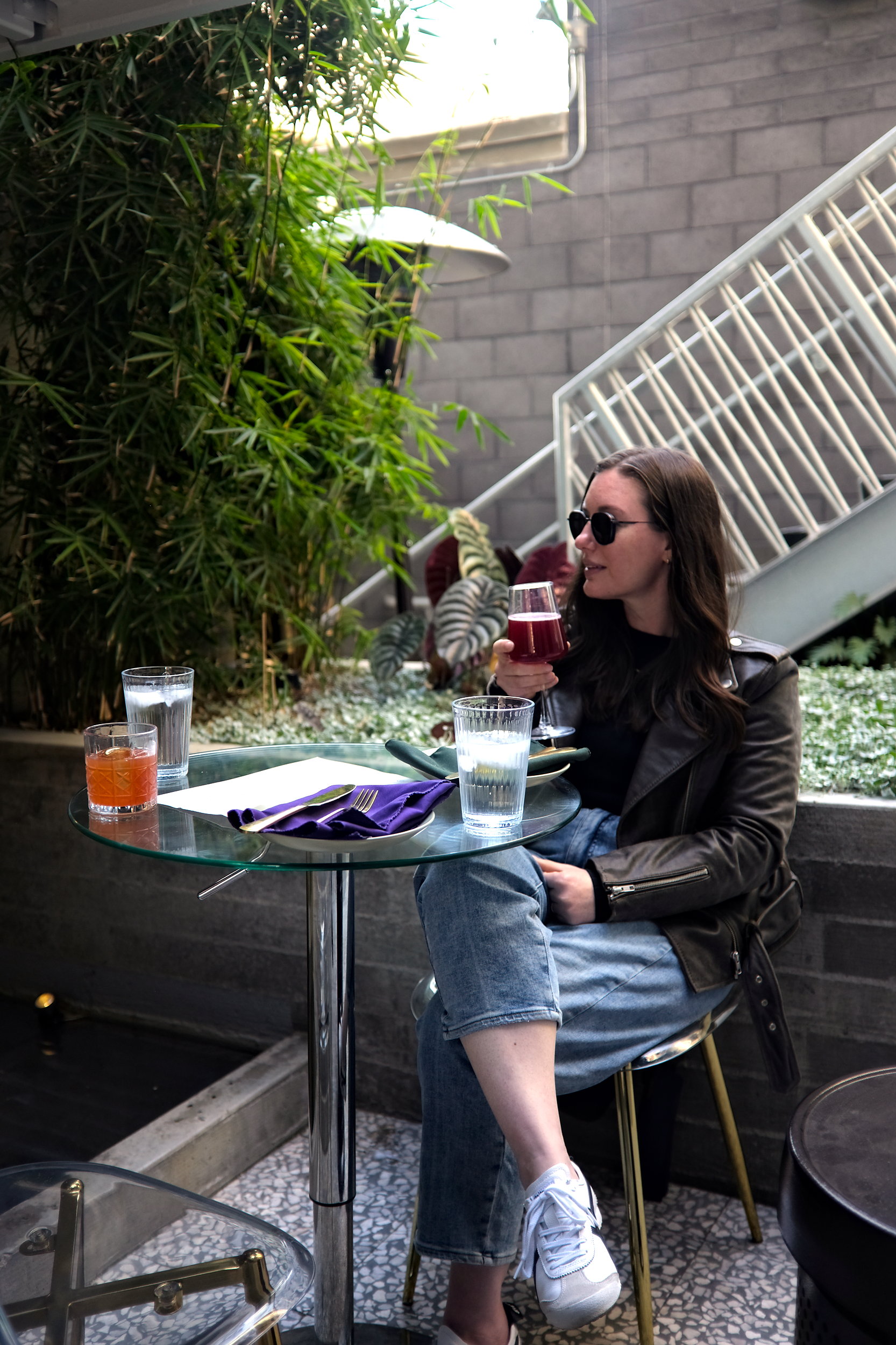 Alyssa sits at Alchemy Choose Thy Poison with a cocktail