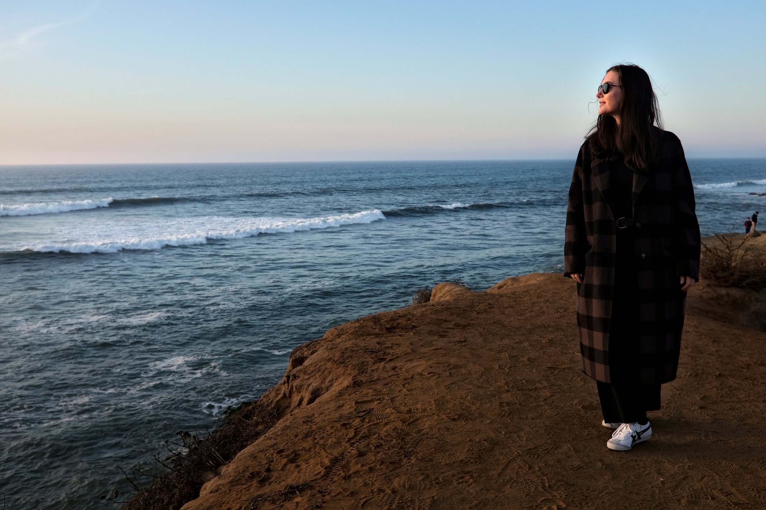 Alyssa walks along Sunset Cliffs at sunset in San Diego