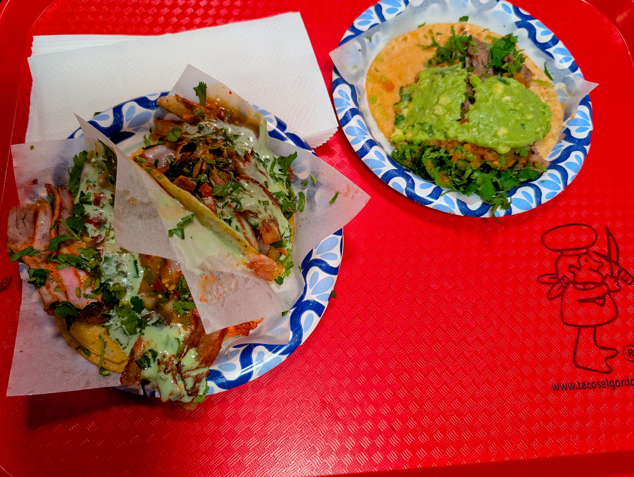 Three tacos on a tray at Tacos El Gordo