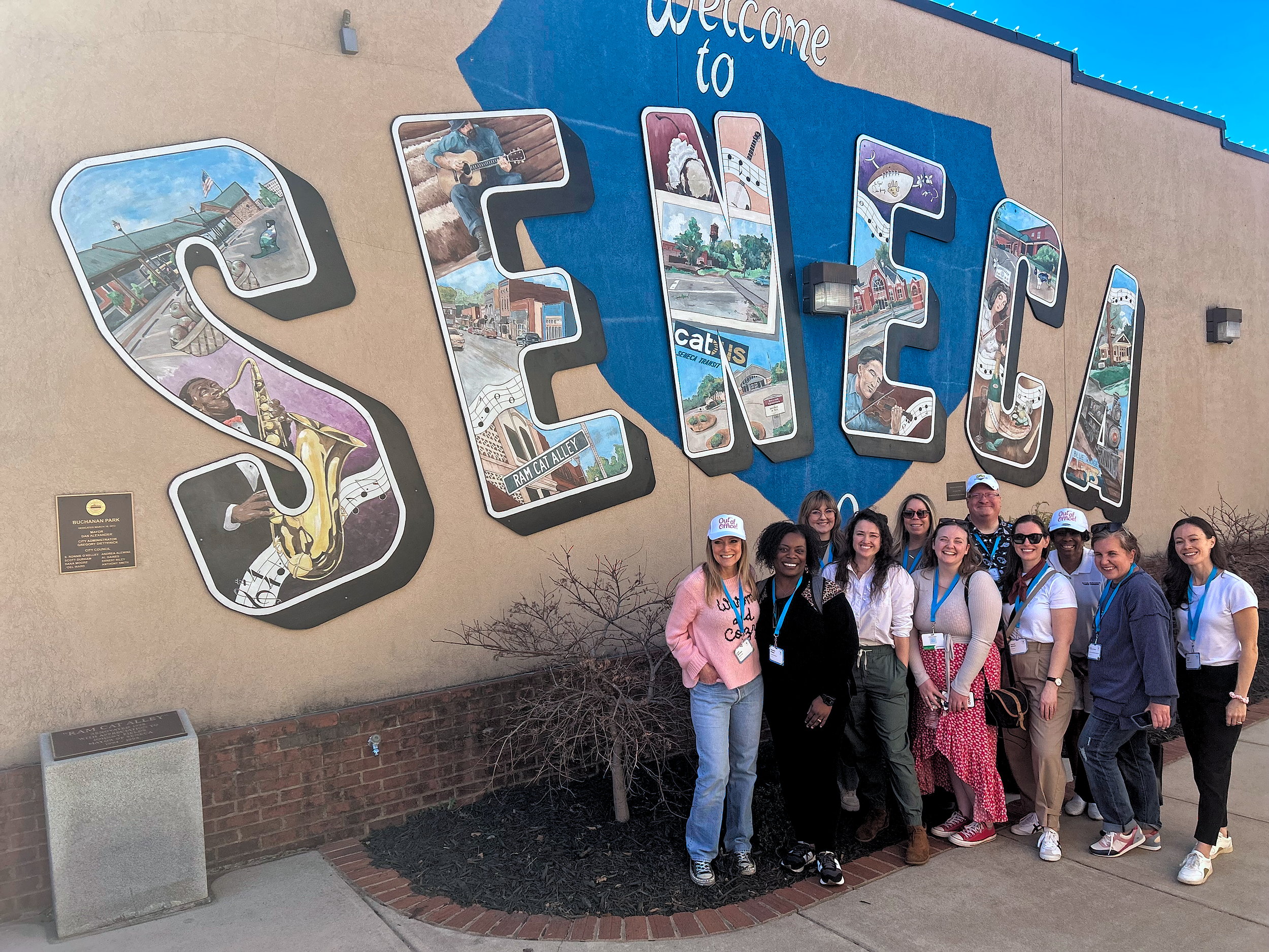 Eleven bloggers, locals, and destination marketing employees in front of a Seneca mural in South Carolina