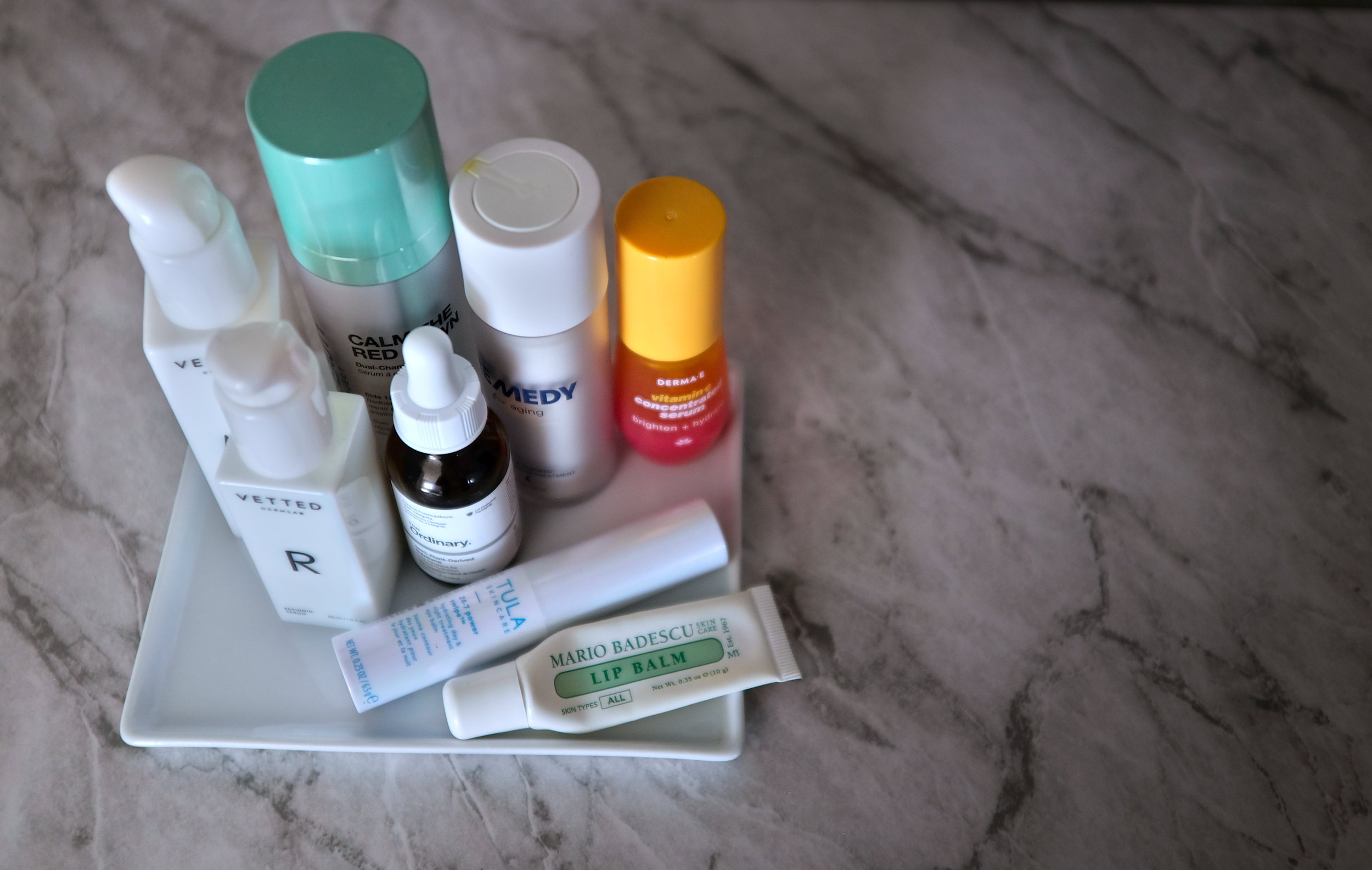 Eight skincare items on a ceramic tray